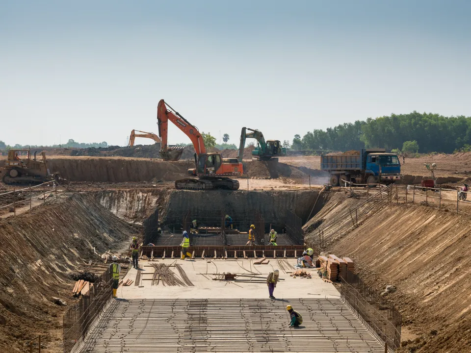 Civil works site with excavator and foundation rebar