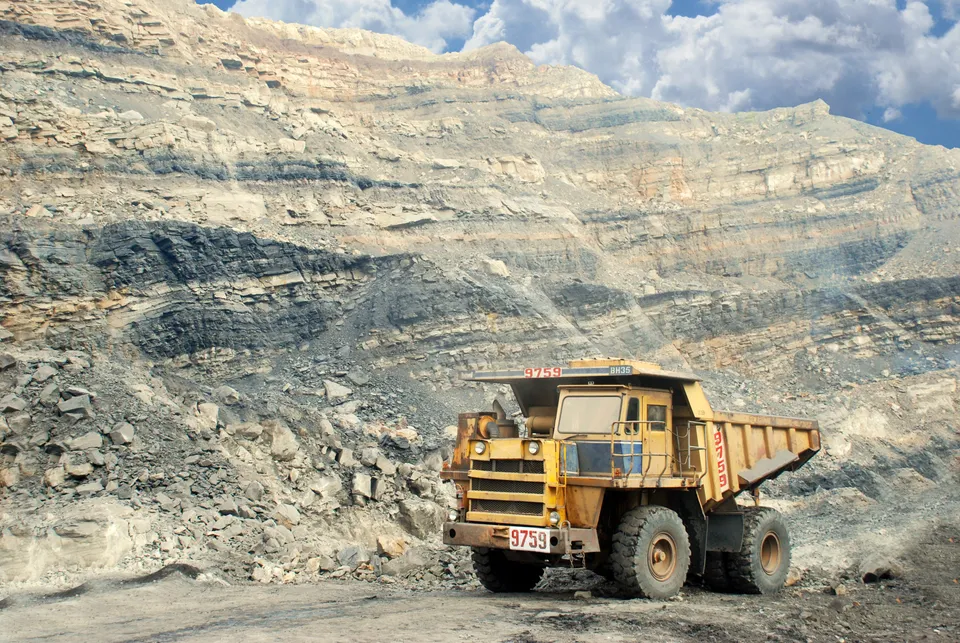 Open-pit mining with haul truck at mine wall